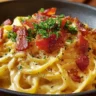 Delicious plate of Bacon Carbonara pasta with creamy sauce and crispy bacon.