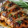 Balsamic baked chicken breast garnished with herbs on a plate