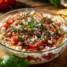 Colorful bruschetta dip served in a bowl with fresh vegetables and toasted bread