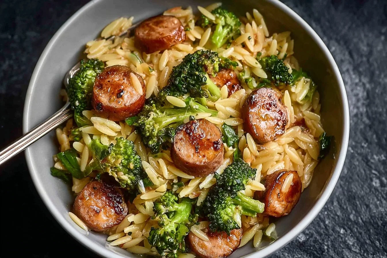 Plate of Chicken Sausage and Broccoli Orzo garnished with herbs