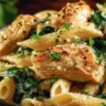 Creamy garlic parmesan chicken pasta garnished with fresh herbs and cheese