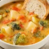 Bowl of creamy vegetable soup with fresh ingredients and herbs