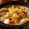 Crock Pot Crack Potato Soup garnished with green onions and bacon