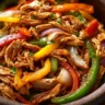 Delicious Crockpot Fajitas with chicken, peppers, and onions in a slow cooker.