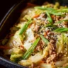 Delicious egg roll in a bowl with fresh vegetables and sauce