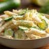 Delicious healthy cucumber pasta salad served in a bowl with colorful veggies.