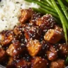 Healthy sesame chicken dish garnished with sesame seeds and vegetables