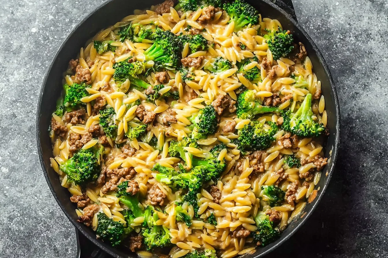 A bowl of quick ground turkey orzo with fresh vegetables and herbs.