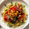 Colorful roasted red pepper salad served in a bowl garnished with herbs.