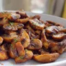 Crispy air fryer mushrooms served on a plate with herbs and spices.