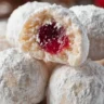Cherry Snowball Cookies dusted with powdered sugar on a plate