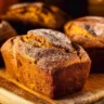 Freshly baked cinnamon swirl pumpkin bread mini loaves on a wooden table