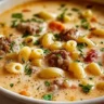 Creamy Parmesan sausage soup with ditalini in a bowl, garnished with herbs.