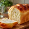 Loaf of easy homemade white bread on a wooden cutting board.