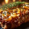 Delicious French Onion Meatloaf topped with melted cheese and caramelized onions