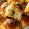 Freshly baked garlic bread rolls on a wooden serving board