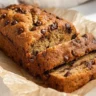 Healthier chocolate chip banana bread slice on a wooden board