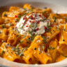Creamy tomato garlic pasta served in a bowl with fresh herbs