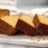 Freshly baked pumpkin bread, rich and buttery, served on a wooden cutting board.