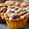 Freshly baked Pumpkin Cinnamon Roll Muffins topped with icing