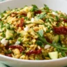 Colorful Sun Dried Tomato Orzo Pesto Salad served in a bowl