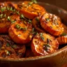 Bowl of walnut maple roasted sweet potatoes garnished with walnuts