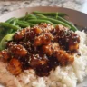 Healthy sesame chicken dish garnished with sesame seeds and vegetables