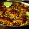 One Pan Mediterranean Chicken and Rice dish served with fresh vegetables